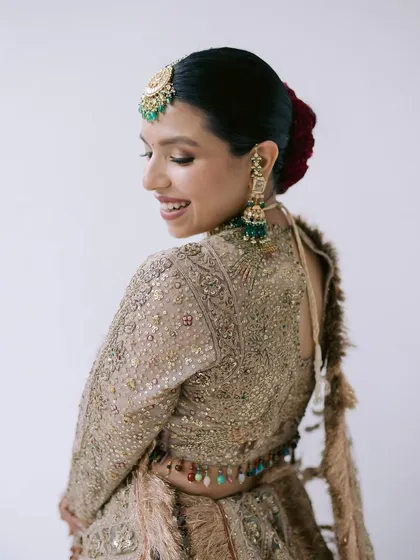 A beautiful profile of Avika on her wedding day. The soft makeup and elegant hair bun with a red rose create a timeless and classic bridal portrait.