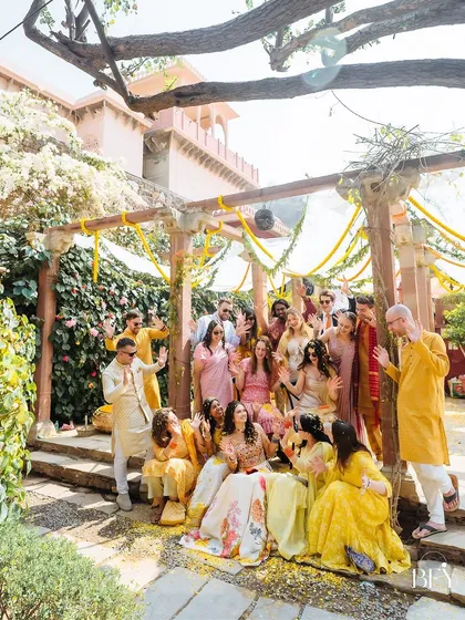 The bride and her entire hype gang posing for a fun and energetic group photo at the Haldi.