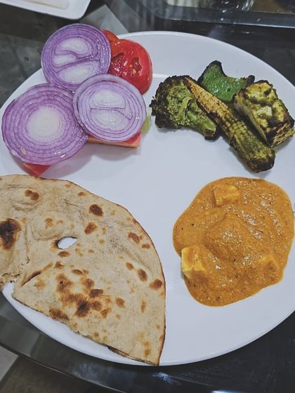 Even weekend cheats can be smart. This client meal features a plate of paneer tikka, tandoori roti, and grilled vegetables, showing how to indulge mindfully.