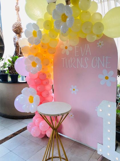 A close-up of the daisy balloon details on the pastel-colored arch.