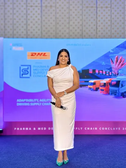 A full-length shot against the impressive stage backdrop of the Pharma & Med Devices Supply Chain Conclave.