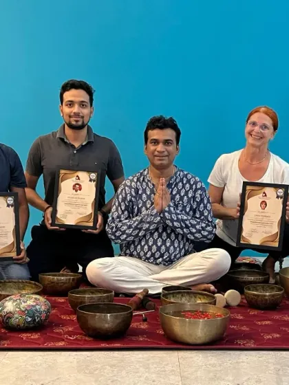 A group of graduates proudly display their Sound Healing certificates, ready to facilitate healing sessions for others.