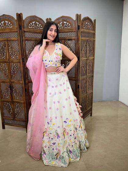 A smiling pose in the off-white floral lehenga, showing how this cheerful pre-loved outfit can brighten up any event.