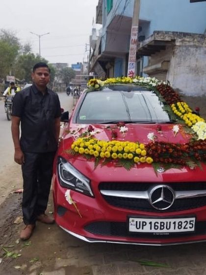 I also decorate luxury cars like this red Mercedes. The decoration uses a combination of yellow marigolds and red roses to complement the car's color.