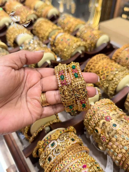 A close look at one of our beautiful antique temple kadas. The detailed craftsmanship with ruby and emerald colored stones makes this a timeless piece, perfect for adding a touch of tradition to any festive or bridal outfit.