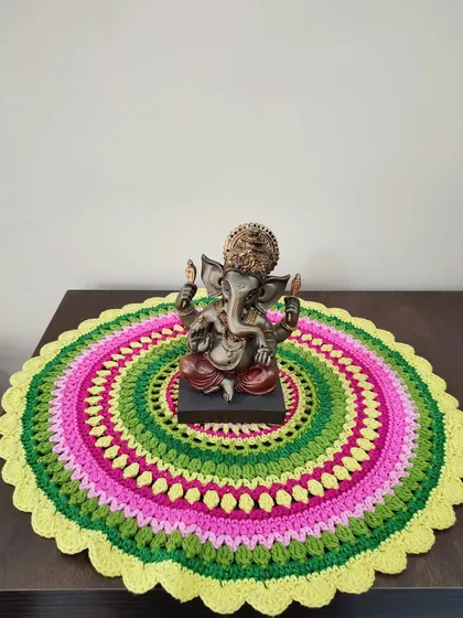 I love using my crochet creations to decorate my home, like this vibrant Viola mandala placed under a Ganesha statue. The bright, concentric circles of color make it a stunning centerpiece or decorative doily for any surface.