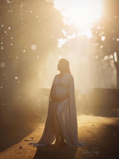 A truly magical shot with golden hour lighting. The cape on this light blue maternity dress catches the light perfectly, creating an angelic glow. This style is wonderful for capturing dramatic, backlit portraits.