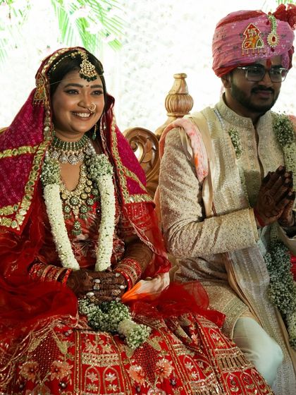 The couple seated during their wedding ceremony, surrounded by tradition and the love of their families. We work to create a setting that honors these timeless rituals.