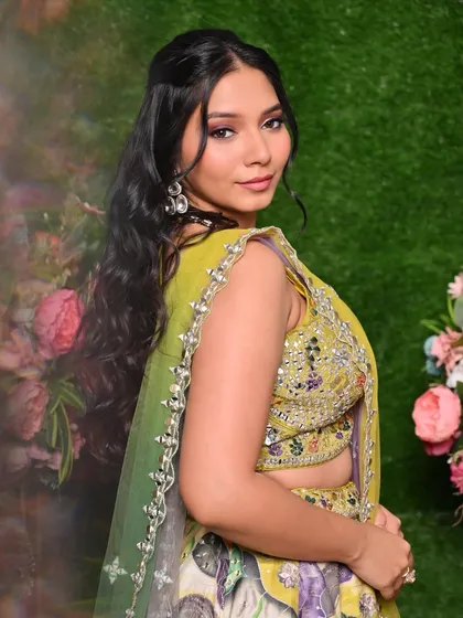 A side view highlighting the soft hairstyle and the beautiful details of the blouse, all part of the complete look.