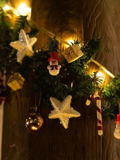 The festive spirit is in every detail. Our wooden pillars are decorated with garlands, twinkling lights, and charming ornaments like snowmen and candy canes for the holiday season.