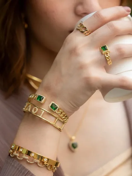 Another angle of our emerald and gold stack. The combination of the emerald stone ring with our "LOVE" cuff bangle is a powerful statement of self-love.