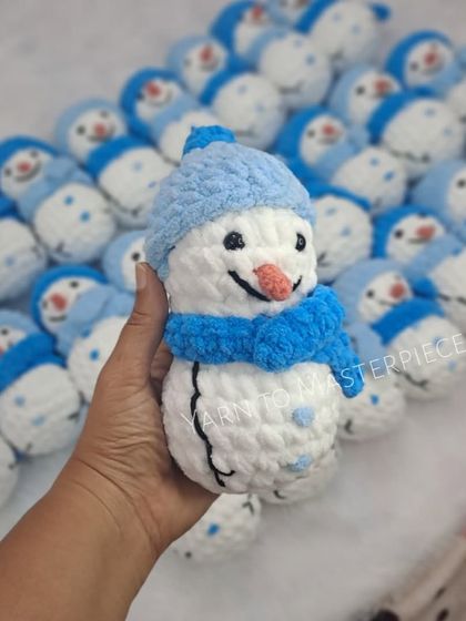 A handful of my snowman plushies, made with soft white yarn and blue winter hats.