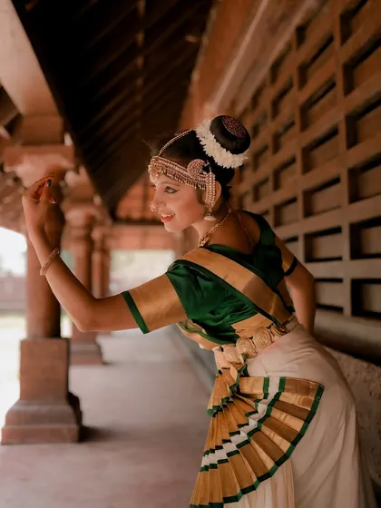 A side profile of a dancer, capturing the elegance of her pose and the intricate details of her hairstyle and costume. The soft light adds a gentle, timeless quality.