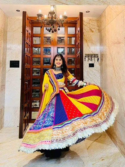 The energy of Garba and Navratri calls for something truly special. This vibrant, multi-paneled lehenga is full of life, featuring a kaleidoscope of colors, traditional patterns, and a playful fringe border, designed to make every twirl unforgettable.