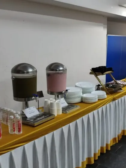 Our beverage and appetizer station, complete with juice dispensers, bottled water, and neatly stacked plates, ready for guests to arrive.