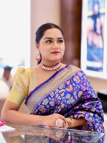 A moment of poise in a stunning royal blue Banarasi saree. This classic look is perfect for hosting a formal wedding reception or a traditional ceremony.