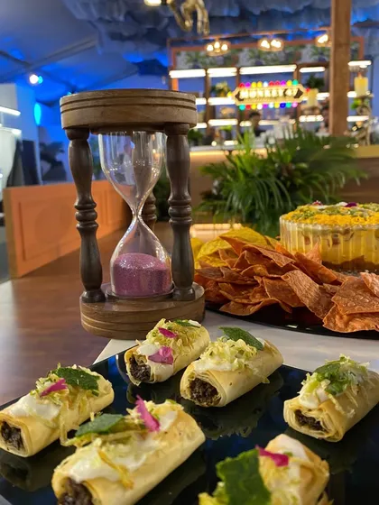 Our Truffle Mushroom Éclairs, elegantly plated next to an hourglass, at the Monkey 47 event.