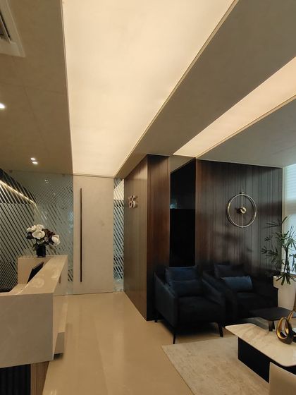 The main reception corridor in the RS office, featuring a clean, minimalist aesthetic. The design balances dark wood paneling with a sleek, light-colored reception desk and strategic lighting to guide movement through the space.