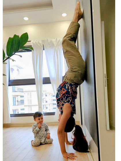 My little one watching me practice a wall-assisted handstand. Her curiosity reminds me to approach my practice with a sense of play and fearlessness.