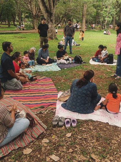 A wider view of our story circle under the trees. Families spread out on their mats, listening in. This image captures the scale of our community and the beautiful, natural setting of our weekend workshops.