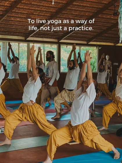 To live yoga as a way of life, not just a practice. Students hold Warrior I, embodying strength and focus, with a teacher observing and guiding the class.