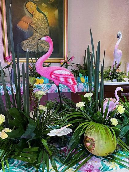 The buffet table for the flamingo party was decorated with tropical greenery, coconuts, and, of course, pink flamingo figures.