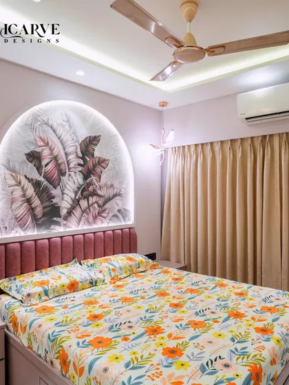 This bedroom design features a custom arched headboard with integrated backlighting, creating a soft, ambient glow. The combination of dusty rose tones and a vibrant floral bedspread makes this a truly personal and serene sanctuary.