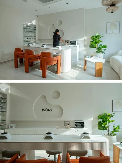 The salon's interior is a symphony of white and organic curves, creating a serene and sophisticated environment for clients.