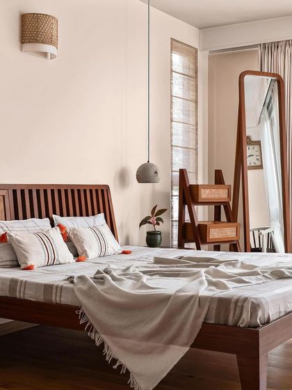 This bedroom, featured in India Today Home, showcases my signature blend of natural materials. The bed features a slatted wood and cane headboard, paired with a custom ladder mirror and concrete pendant light.