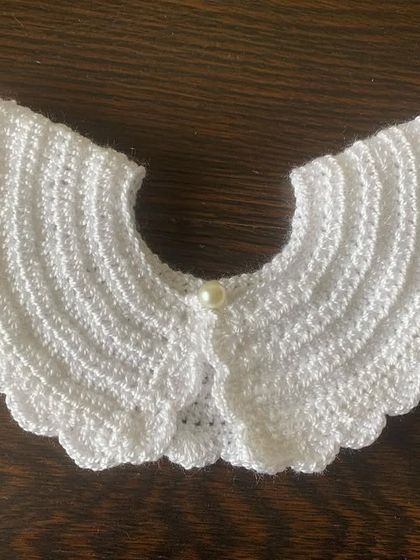 Another view of the classic white crochet collar, perfect for adding a sophisticated touch to a dark top or dress.