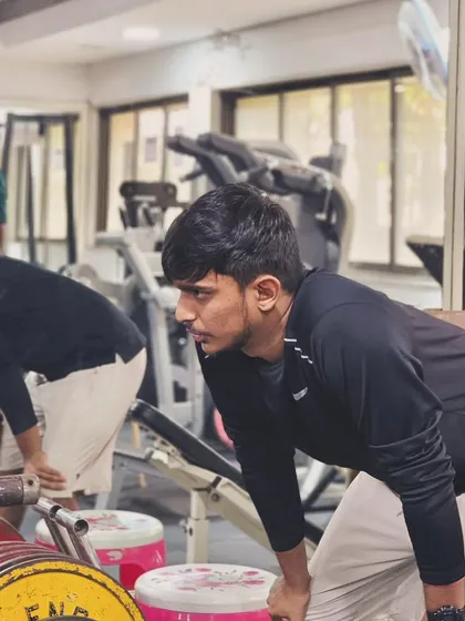 Players focus on their form during a weightlifting session in the gym, building the foundational strength required for high-level badminton.