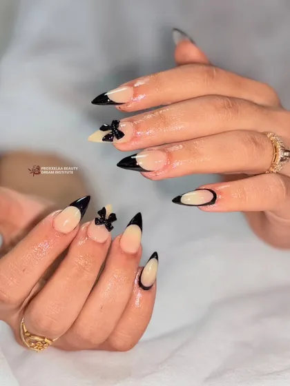 A detailed shot of the chic black French tips with 3D bows. The stiletto shape enhances the elegance of the design, making it both modern and timeless.