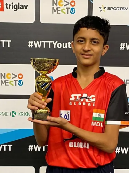 A smiling Atharva holding his first international trophy.