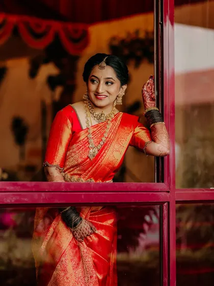 A bride's portrait is more than just a photo; it's a reflection of her joy and anticipation. This image captures her radiant smile and the intricate beauty of her traditional South Indian bridal attire.