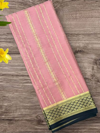 A soft onion pink pure crepe Mysore silk saree with elegant gold stripes and a classic black border.