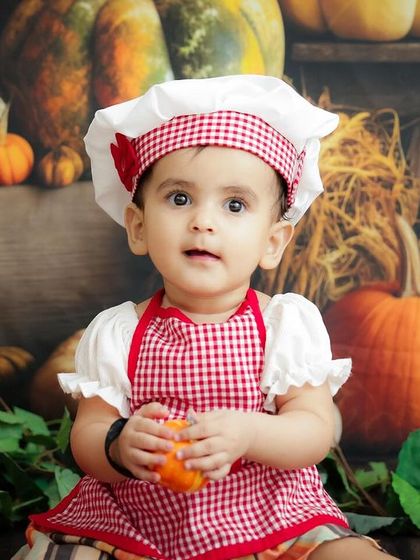 Our little pumpkin patch chef! This autumn-themed shoot with a chef's hat and apron is a fun way to celebrate the season.