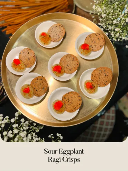 Sour Eggplant Ragi Crisps presented as individual portions. The tangy eggplant relish is paired with a crunchy, wholesome ragi crisp for a unique flavor combination.