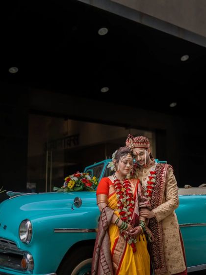 A classic portrait of a Maharashtrian couple with a vintage Dodge car, blending tradition with a touch of retro style for a unique wedding photo.
