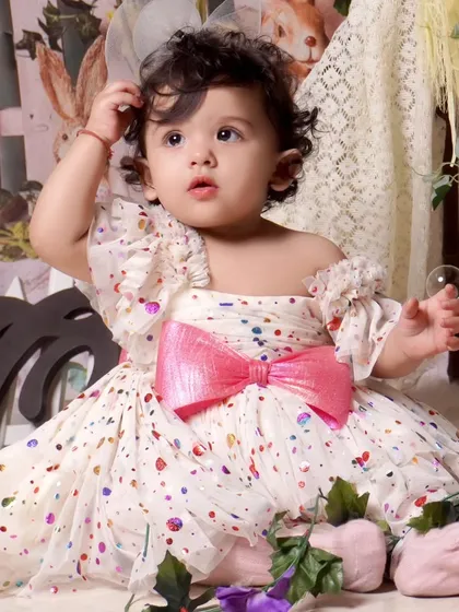 A beautiful portrait of a little girl in a polka-dot dress during her pre-birthday tent-themed shoot. The single bubble adds a touch of magic to the photo.