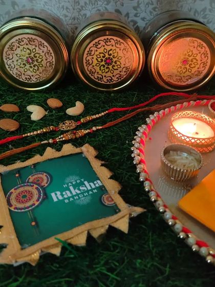 A top-down view of the elegant lids on our Rakhi hamper jars, placed next to a festive thali with a diya and rakhis.
