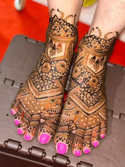 A heavy, full-coverage bridal feet design. The intricate patterns and bold lines create a stunning look that complements a full bridal mehendi.