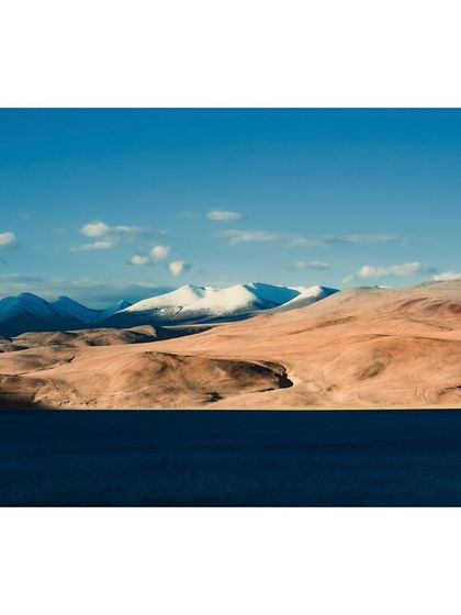 The stark beauty of the Ladakhi landscape near Tso Moriri, where the barren brown mountains meet the deep blue of the lake.