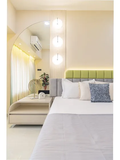 This shot highlights the unique arched mirror and dressing table nook. The design uses curves and soft lighting to create an elegant and feminine space.