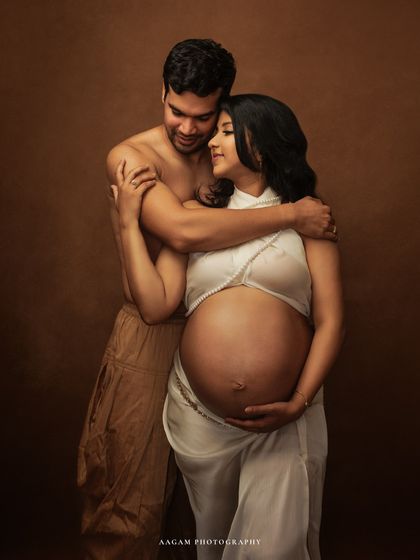 A radiant mom-to-be wrapped in a simple white silk drape. This fine art maternity portrait focuses on the beautiful form of pregnancy with elegance and grace.