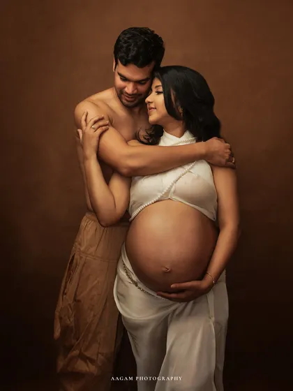 Wrapped in a simple white drape, this couple's portrait is raw, intimate, and powerful. It highlights the beauty of the bare bump and the deep connection between them.