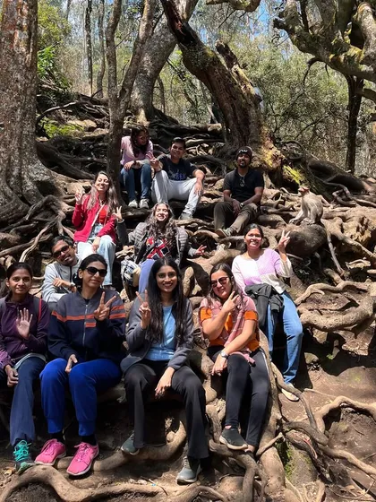 Posing on the famous gnarled roots of a tree in Kodaikanal. These unique spots make for great photos and memories.
