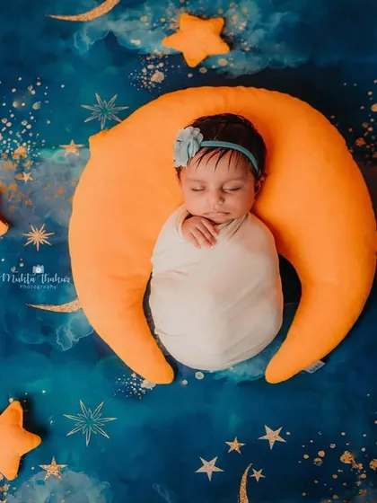 Sleeping on a crescent moon surrounded by stars. This is one of my favorite setups for creating truly magical and whimsical newborn portraits.