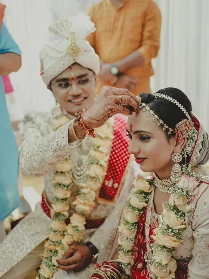 A close-up of the groom applying the ceremonial mark on the bride's forehead.
