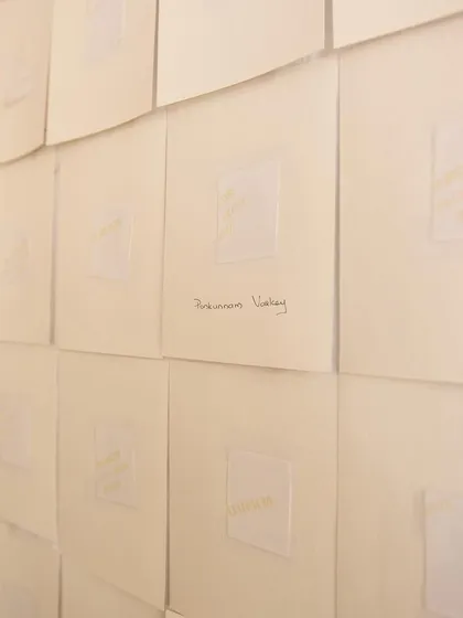 A detail shot of the wall installation for "Mindscapes," where each piece of paper represents a story or a memory, creating a powerful visual tapestry.