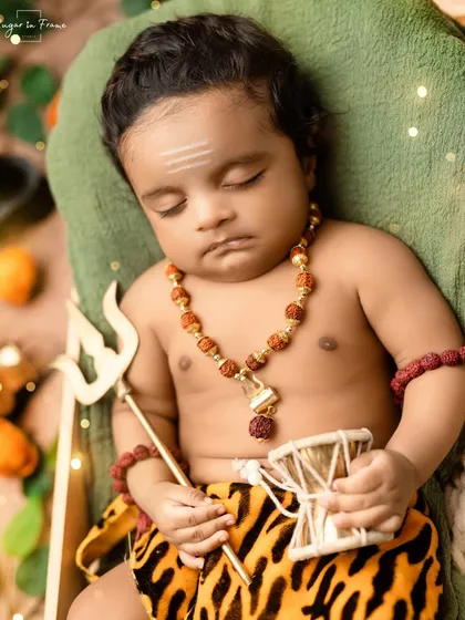 A close-up of our little Mahadev, holding a damru. We pay close attention to details like the tripundra on the forehead to make these spiritual-themed shoots authentic.